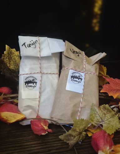 Twee ingepakte geschenken met een stukje touw, omringd door herfstbladeren.